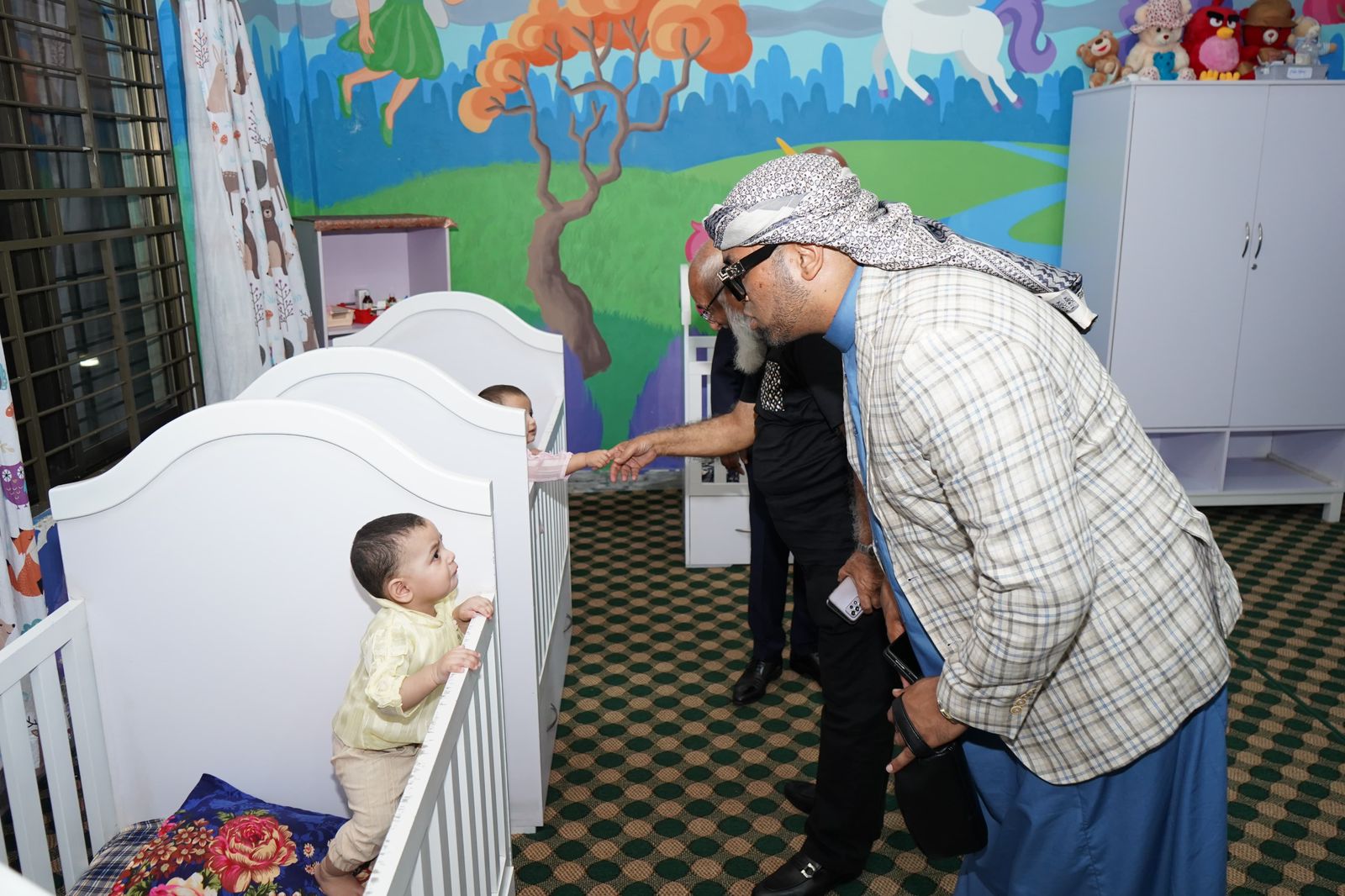 Mohamed Sameer Ismail greeting a child at the KORT orphan care nursery