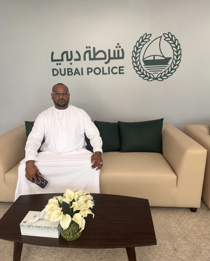 Mohamed Sameer Ismail seated beneath the Dubai Police insignia during a visit